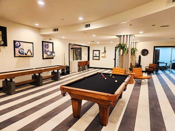 Clubroom featuring coffee bar, business center, tv/media area, game area, and kitchen